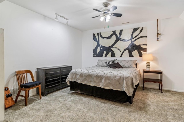 bedroom with carpet floors, rail lighting, visible vents, ceiling fan, and baseboards