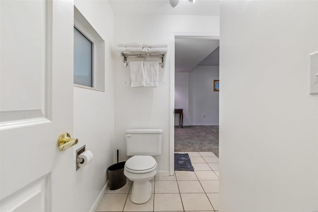 bathroom with toilet, baseboards, and tile patterned floors