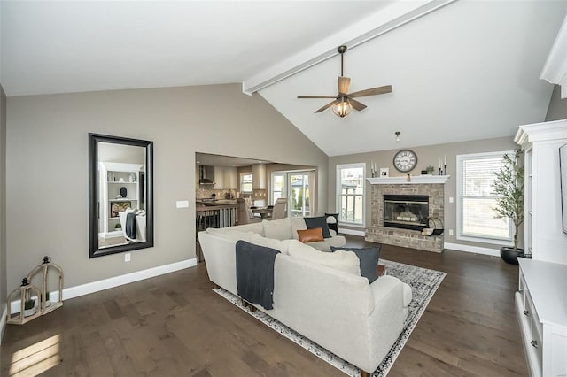 living room with dark wood-style floors, beamed ceiling, a fireplace, and a wealth of natural light