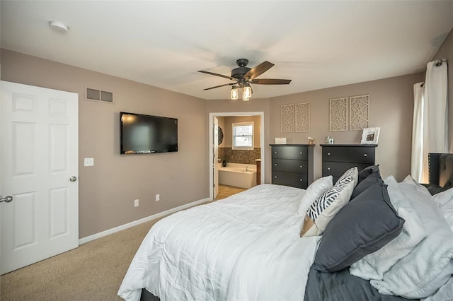 bedroom with light colored carpet, visible vents, ceiling fan, ensuite bath, and baseboards