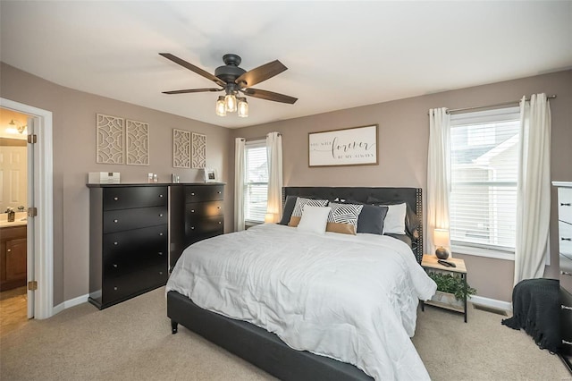 bedroom featuring baseboards, a ceiling fan, connected bathroom, carpet flooring, and a sink