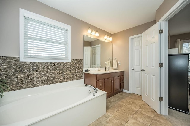 bathroom with a garden tub, tasteful backsplash, and vanity