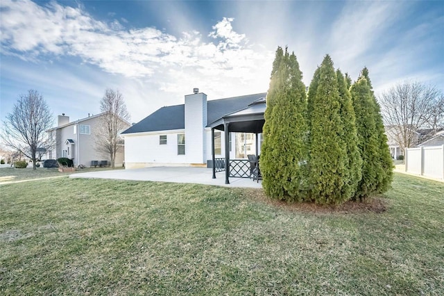 exterior space featuring a yard, a chimney, a gazebo, and a patio