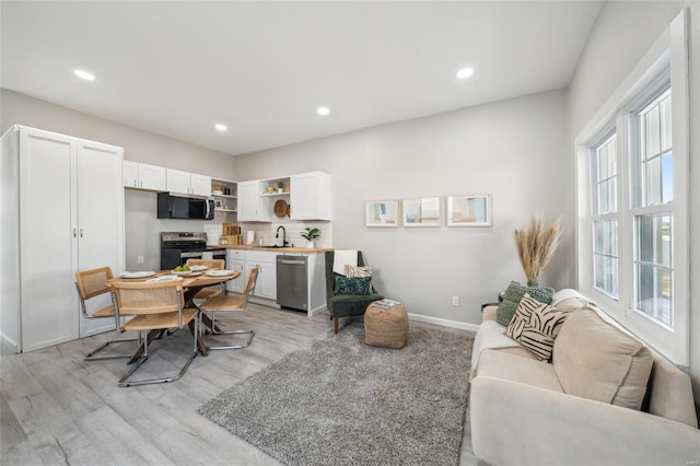 interior space with light wood-style floors, recessed lighting, and baseboards