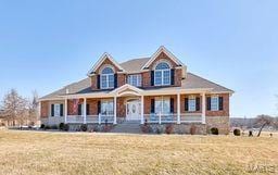 view of front of property with a porch and a front lawn