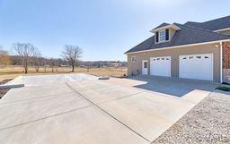 view of home's exterior with concrete driveway and a garage