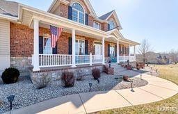 view of front facade with brick siding and a porch