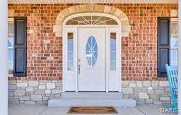 entrance to property featuring brick siding