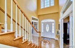 foyer with stairs, a high ceiling, and wood finished floors