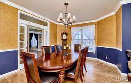 dining area featuring wood finished floors, a wainscoted wall, a chandelier, and ornamental molding