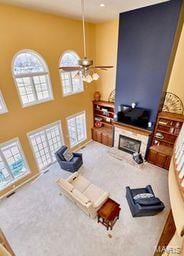 carpeted living room featuring a fireplace and a towering ceiling