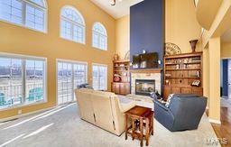 living area featuring a fireplace and a high ceiling