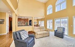 living room featuring baseboards and a towering ceiling