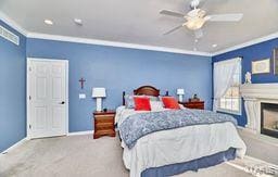 bedroom featuring ornamental molding, a ceiling fan, carpet flooring, a fireplace, and baseboards