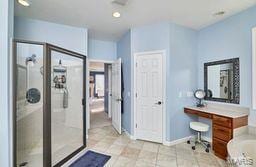 full bathroom featuring vanity, a shower stall, a bathtub, and baseboards