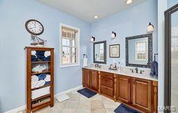 bathroom with double vanity and baseboards