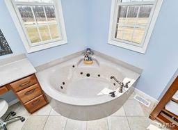 bathroom featuring tile patterned flooring, a tub with jets, and a healthy amount of sunlight