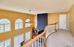 hall featuring carpet, an upstairs landing, and baseboards