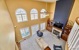 living room featuring a fireplace, a towering ceiling, and ceiling fan