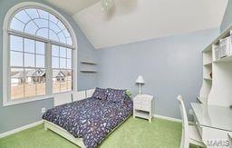 bedroom with baseboards, carpet floors, and vaulted ceiling