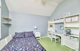 bedroom with visible vents, baseboards, carpet, and vaulted ceiling