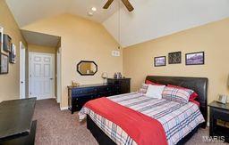 bedroom with carpet flooring, a ceiling fan, and lofted ceiling