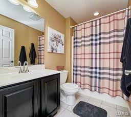 bathroom with vanity, tile patterned floors, shower / bath combination with curtain, and toilet