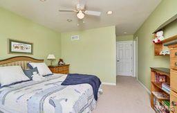 carpeted bedroom featuring ceiling fan and baseboards