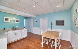 dining room with a paneled ceiling and wood finished floors