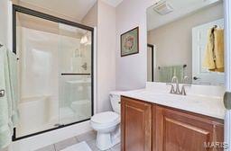 full bath with tile patterned floors, visible vents, toilet, a stall shower, and vanity