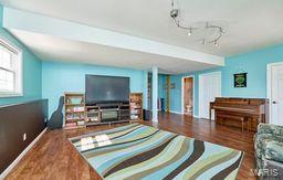 living area featuring rail lighting and wood finished floors