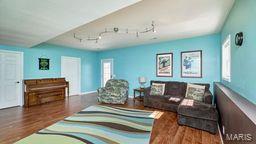 living room with rail lighting and wood finished floors