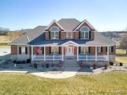 view of front of home with covered porch and a front lawn