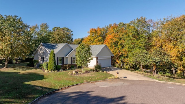 view of front facade with an attached garage, concrete driveway, and a front yard