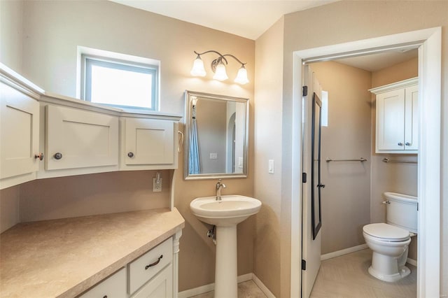 bathroom with toilet and baseboards