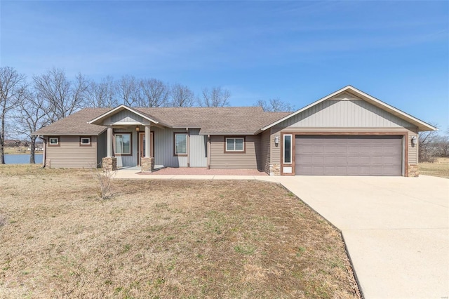 ranch-style house featuring a front lawn, driveway, a shingled roof, and an attached garage