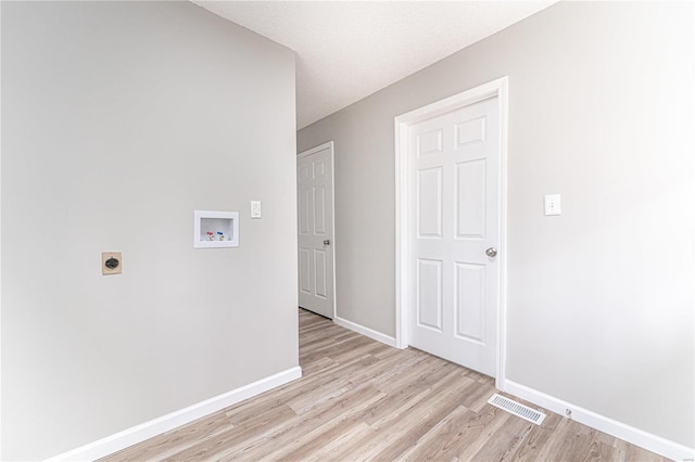 interior space featuring electric dryer hookup, visible vents, baseboards, hookup for a washing machine, and laundry area