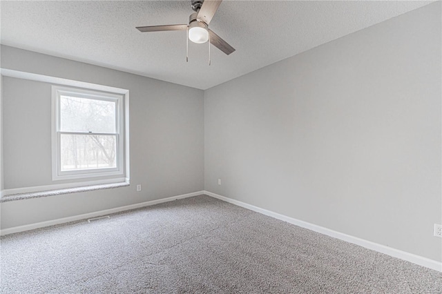 carpeted spare room featuring visible vents, a textured ceiling, baseboards, and a ceiling fan