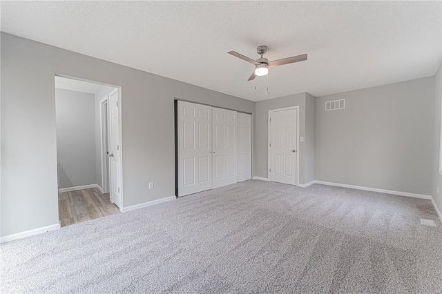 unfurnished bedroom with baseboards, visible vents, carpet floors, and a closet