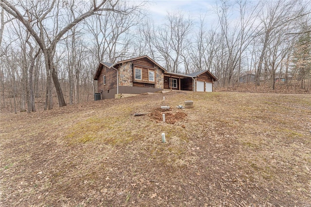 view of front of property featuring a garage and stone siding