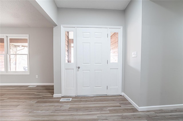 entryway featuring visible vents, baseboards, and light wood-style floors