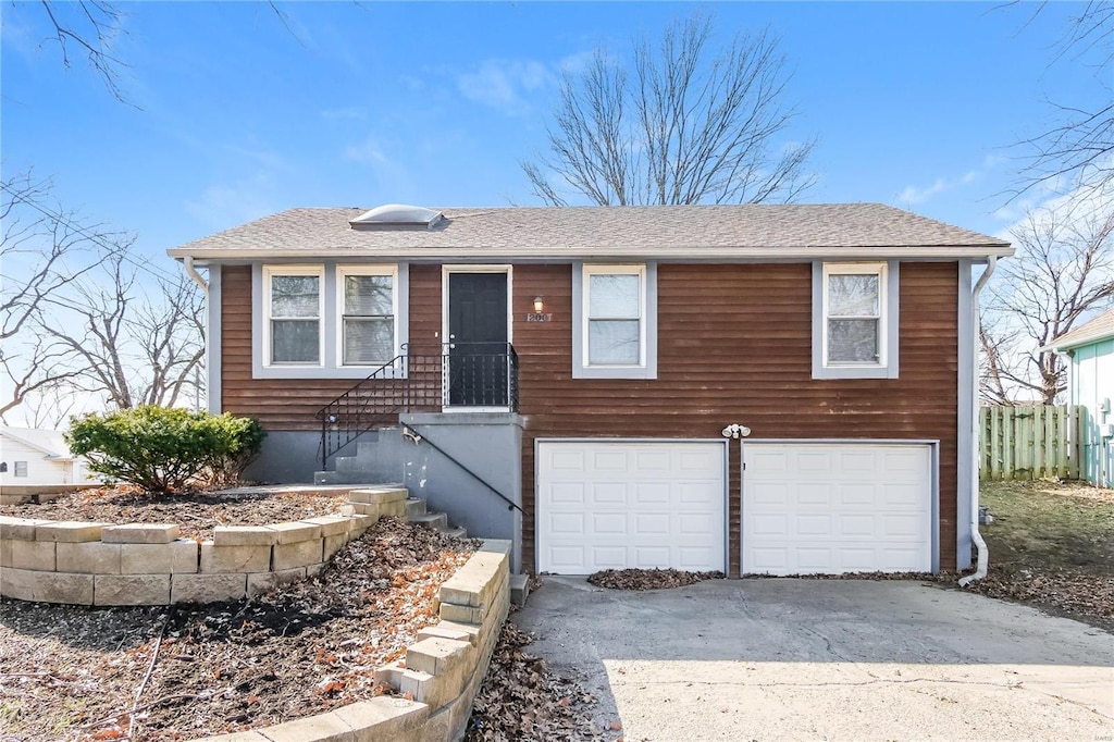 ranch-style home with a shingled roof, driveway, and an attached garage