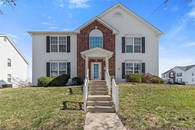 view of front facade featuring brick siding and a front yard