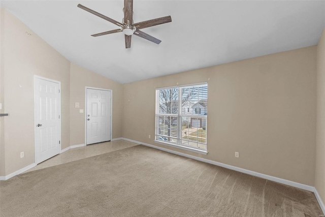 carpeted spare room with lofted ceiling, a ceiling fan, and baseboards