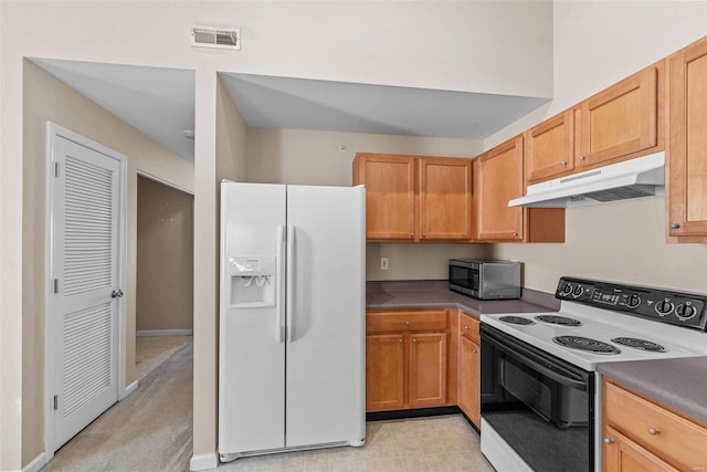 kitchen featuring under cabinet range hood, electric range oven, white fridge with ice dispenser, stainless steel microwave, and dark countertops