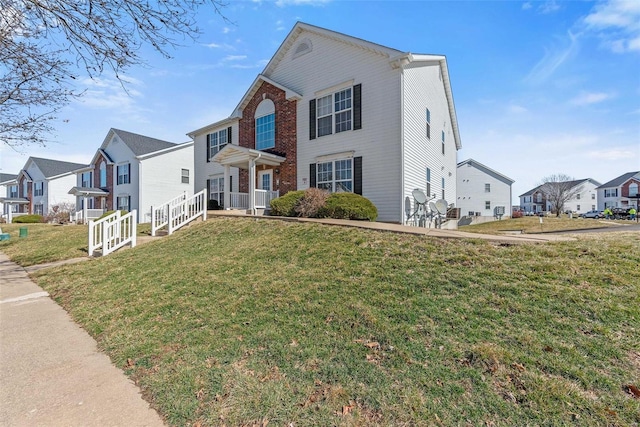 view of front of house featuring a residential view, a front lawn, and brick siding