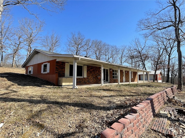 view of front of home featuring brick siding and a patio area