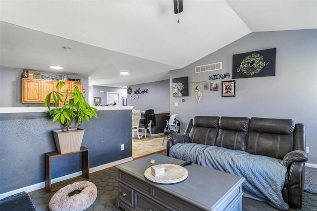 living area with baseboards, visible vents, and vaulted ceiling