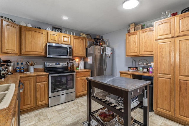 kitchen featuring appliances with stainless steel finishes, brown cabinetry, light countertops, and a sink