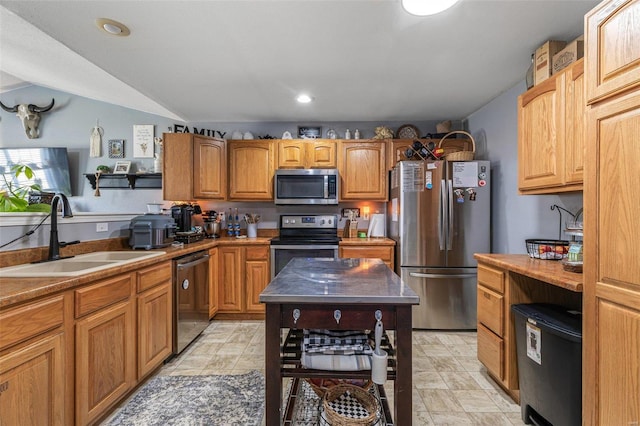 kitchen with stainless steel appliances, recessed lighting, brown cabinetry, and a sink